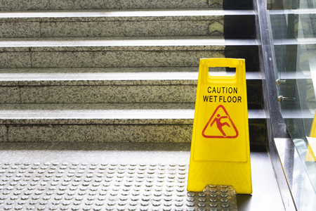 Warning sign for wet floor near the stairの写真素材