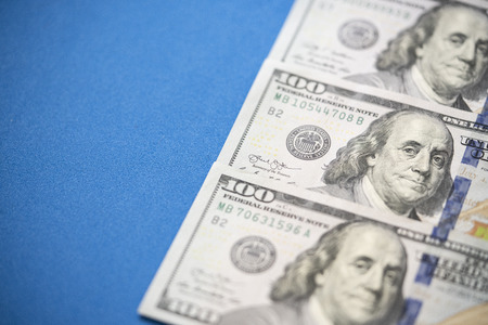 US one hundred dollars bills money on blue backgroundの写真素材