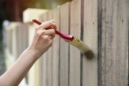 Applying protective varnish on a wooden fence, diy conceptの写真素材