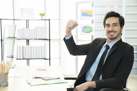 Portrait of businessman pushing his hand up to cheer up, business success concept