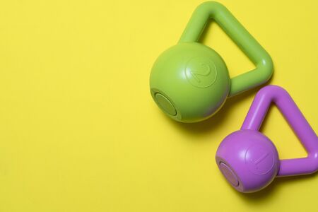 close up of kettlebell or sport equipment on a yellow background, sport and healthy concept
