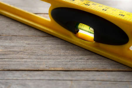 Yellow building level on the old wood table, engineering work tool conceptの写真素材