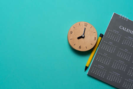 close up of calendar and alarm clock on the green table background, planning for business meeting or travel planning conceptの写真素材