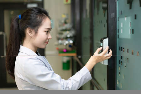 Woman scanning fingerprint and access control for enter security system in a office building