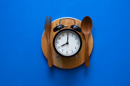 Food clock. Healthy food concept on blue backgroundの写真素材