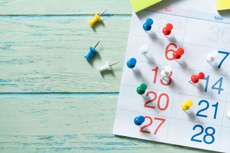 close up of calendar and pin on the green table background, planning for business meeting or travel planning conceptの写真素材
