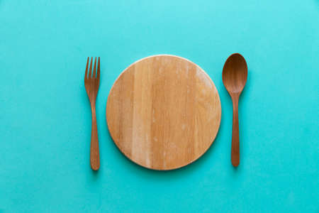 spoon and fork on cutting board with green table background, food and healthy conceptの写真素材