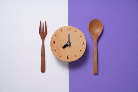 Food clock. Healthy food breakfast concept on white and purple table backgroundの写真素材