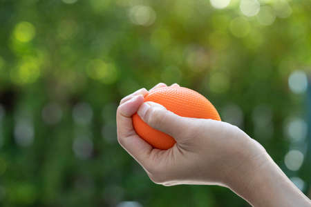 woman hand holding stress ball on green backgroundの写真素材