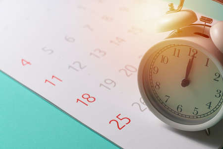 close up of calendar and alarm clock on the green table background, planning for business meeting or...