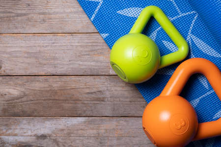 kettlebell and blue yoga mat on table, fitness healthy and sport concept