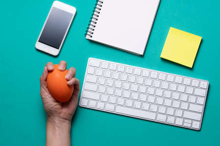 close up of computer, stress ball and computer keyboard with green background, stress at office...