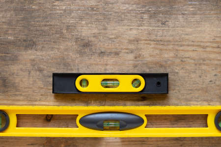Yellow building level on the old wood table, engineering work tool conceptの写真素材