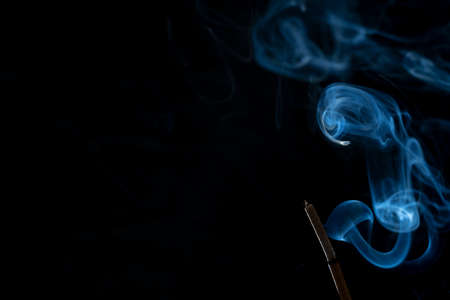 Incense stick with abstract of smoke on black backgroundの写真素材