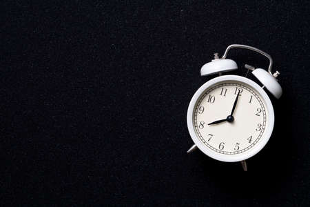 Retro alarm clock on black table background, vintage styleの写真素材