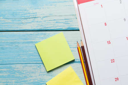 close up of calendar and pencil on the blue table background, planning for business meeting or...