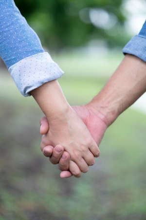 Lovers couple holding hands between boyfriend and girlfriend, love and romance conceptの写真素材