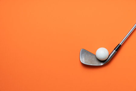 golf ball and golf club on orange background, sport conceptの写真素材