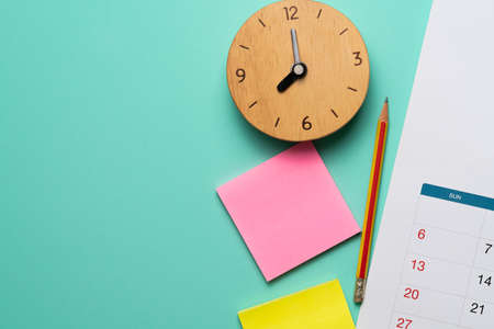 close up of calendar and alarm clock on the green table background, planning for business meeting or...