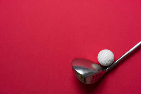 golf ball and golf club on red table background, sport conceptの写真素材