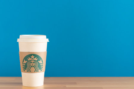 Bangkok, Thailand - january 24, 2021: Close up a green Starbucks coffee cup on the table with blue backgroundのeditorial素材