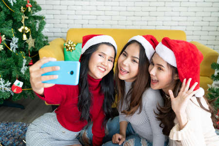 Asian friend group team taking selfie with smartphone in the home party , corporate, celebration and...