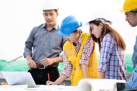 Asian engineers were consulted together and plan on the meeting outdoor in construction site, engineering and technology conceptの写真素材