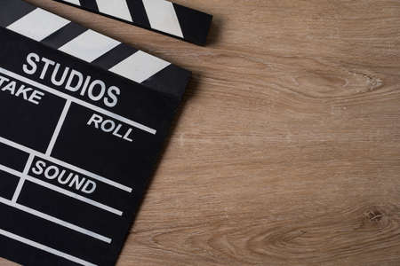 movie clapper on wooden table background ; film, cinema and video photography concept