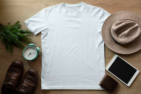 Mockup of a white t-shirt blank shirt template with accessories on the wooden table background, lifestyle and travel conceptの写真素材
