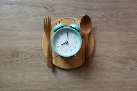 Food clock spoon and fork, Healthy food breakfast concept on black backgroundの写真素材