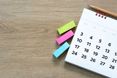 close up of calendar, pencil, note pad on the wooden table background, planning for business meeting...