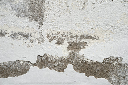 Close up white color painted old peeling or failing cracked plaster wall concrete grunge texture backgroundの写真素材