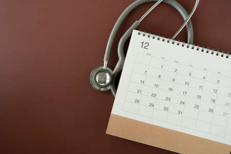 Top view of stethoscope and calendar on the table background, schedule to check up healthy conceptの写真素材