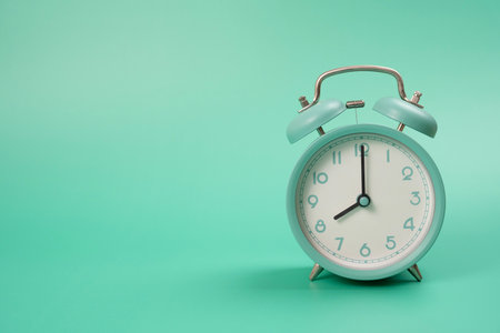 Retro alarm clock on green table background, vintage style, flat layの写真素材