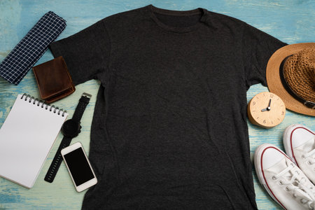 Mockup of a black t-shirt blank shirt template with accessories on the wooden blue table background,...