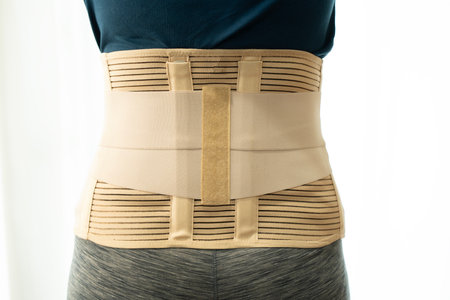 young asian woman wearing back support for protect her back, medicine and healthy concept