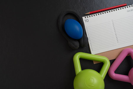 Time for exercising calendar and dumbbell with black background, sport and healthy concept