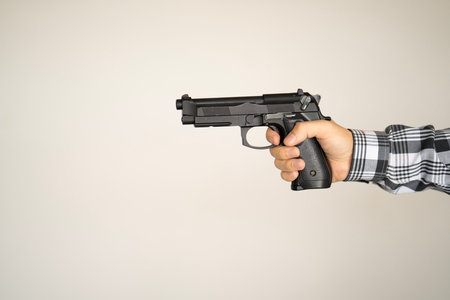 Hand of man holding a gun
