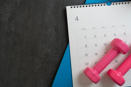 Time for exercising equipment dumbbell and calendar with black background, sport and healthy concept