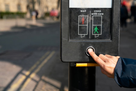 Hand finger pressing or pushing on stop request button at crosswalk, Traffic light at square in urban or cityの写真素材