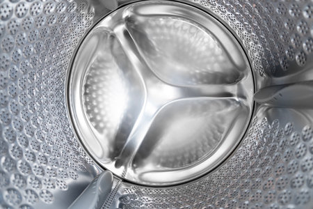 Close up internal view of an empty washing machine drum during washの写真素材
