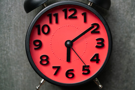 Close up of retro red alarm clock on black table background, vintage style, flat layの写真素材