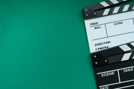 movie clapper on green table background ; film, cinema and video photography concept