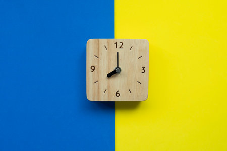 Retro alarm clock on blue and yellow background, vintage style, flat layの写真素材