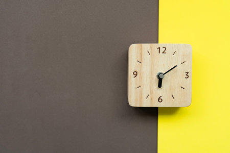Retro alarm clock on brown and yellow table background, vintage style, flat layの写真素材