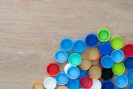 Close up plastic bottle caps on a wooden table.