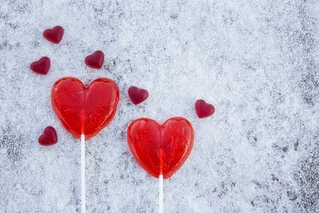 Two sweet red hearts on a snow backgroundの写真素材