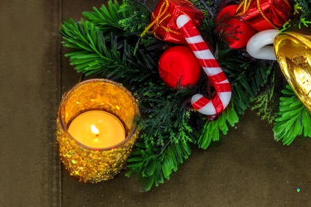 Gold Christmas candlestick c fir branches and Christmas decorations on the brown cloth background