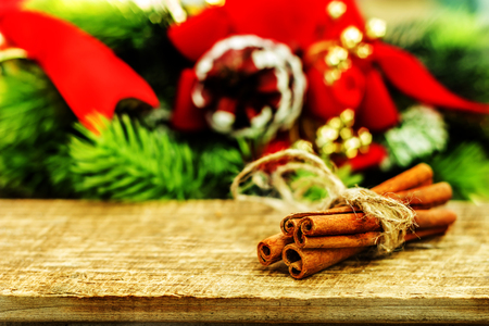 Rustic Christmas wooden background with fir tree, red balls and cinnamon sticks.の写真素材