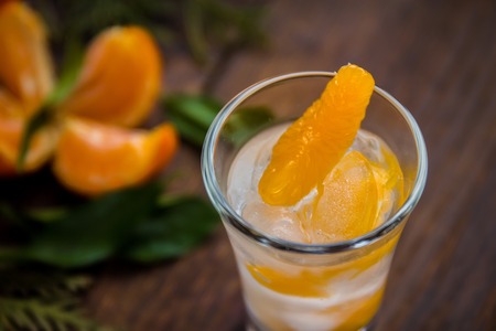 Glass with fresh juicy ripe Mandarins Tangerines, ice. Copy space and Closeup on dark background. Top view. Horisontalの写真素材
